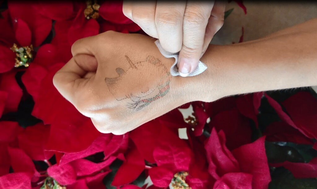 person showing how to remove temporary tattoos